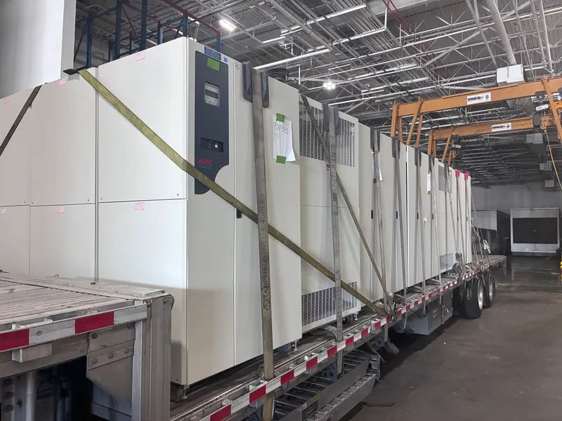 APC UPS cabinets secured on a flatbed trailer during equipment recovery
